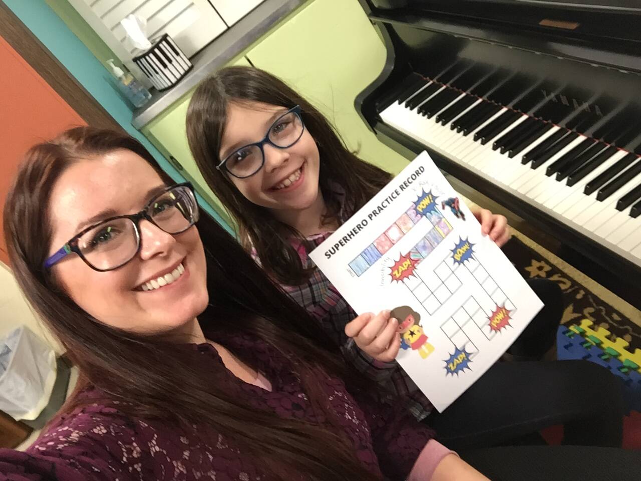 greta practice challenge Ms. Sara and a young girl student at piano lessons showing a practice game